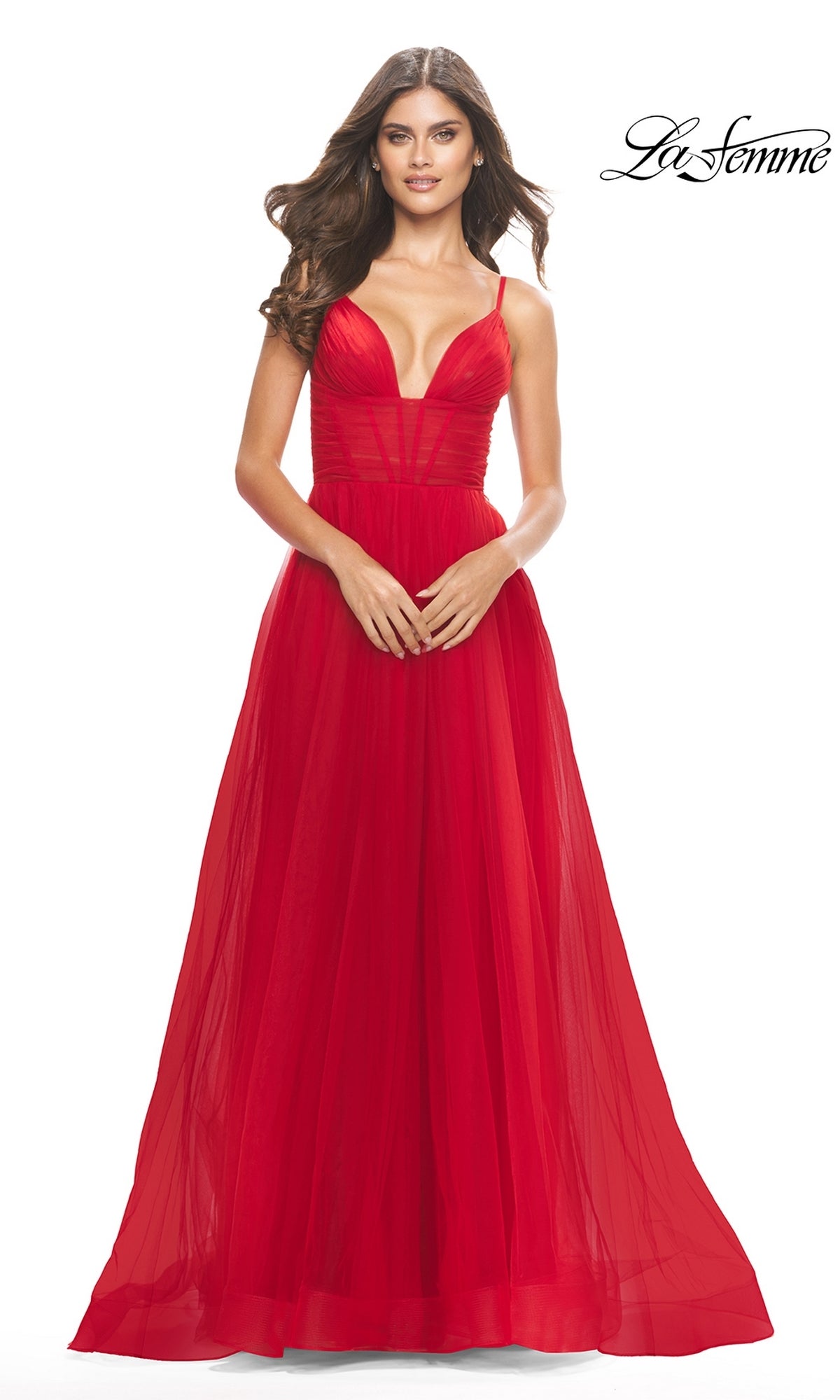 A woman in the Sheer-Waist La Femme Long Prom Ball Gown 31147, featuring a deep V-neckline and thin straps, poses against a white background. The elegant formal dress shines with sophistication. La Femme logo appears in the top right corner.